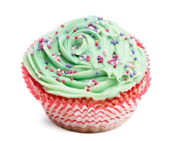 istock Cupcake with green icing and hundreds and thousands against white background in front of white background 824180016