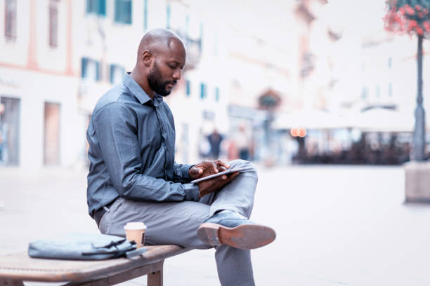 istock Businessman sitting on the bench and using digital tablet 824182820