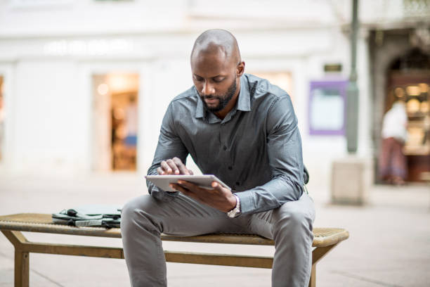 istock Businessman sitting on the bench and using digital tablet 824182828