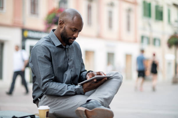 istock Businessman sitting on the bench and using digital tablet 824182838