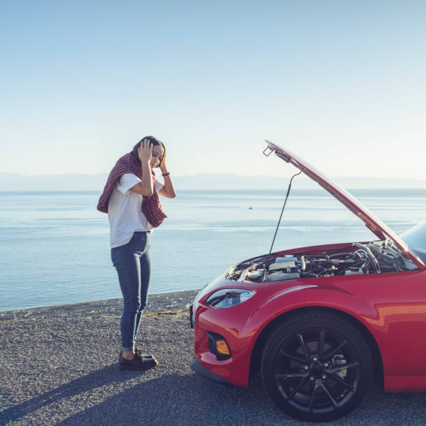 woman stand by the broken car