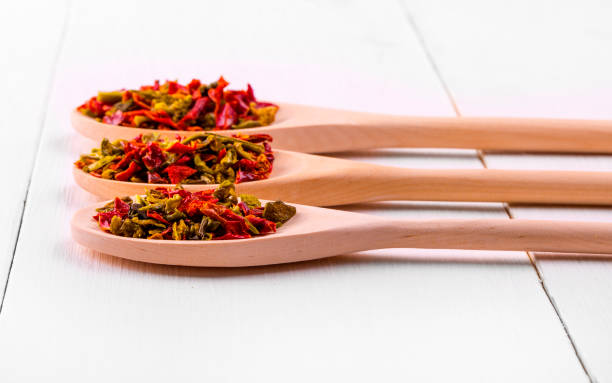 istock Three wooden spoons with spices on a white wooden table. 824185956