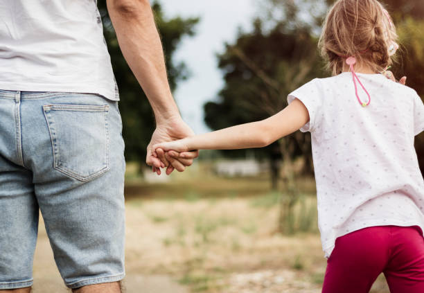 istock Father and daughter holding hands in the park 824192978