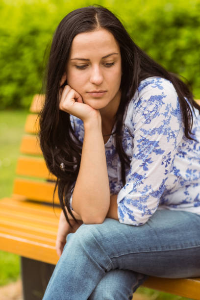 istock Thoughtful casual brunette sitting on bench 824193322