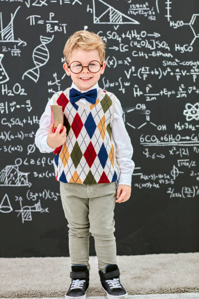 istock Smart boy in front of black board 824198384