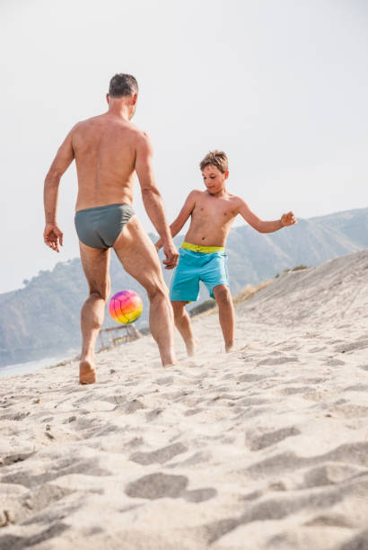 istock Father And Son Playing Soccer 824200882