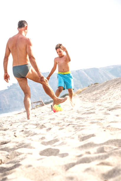 istock Father And Son Playing Soccer 824200888