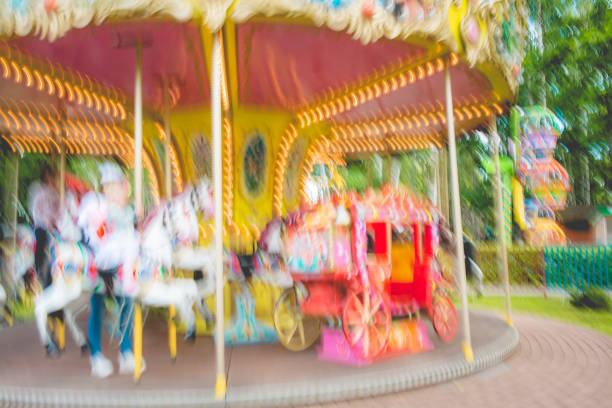 Brothers and sister sitting on chain carousel or chair swing ride. The kids are enjoying the ride at the travelling carnival despite the COVID-19 pandemic.Nikon D850