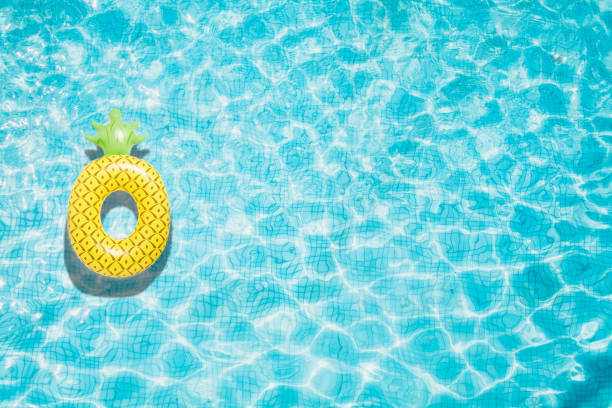 Pineapple pool float, ring floating in a refreshing blue swimming pool stock photo