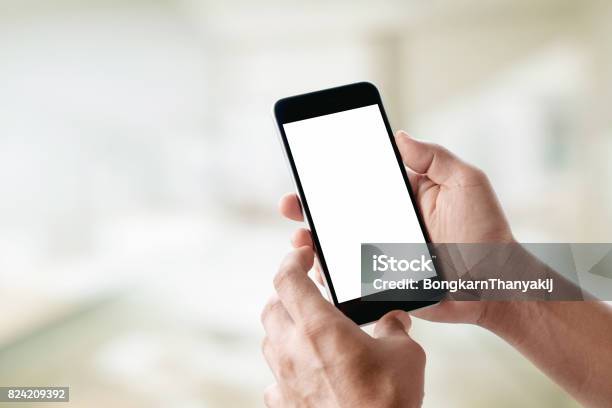 Mock Up Smartphone Man Hands Holding Mobile Phone With Abstract Bokeh Background Stock Photo - Download Image Now