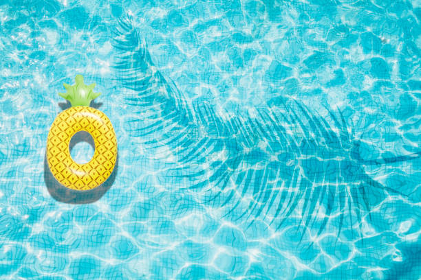 Pineapple pool float, ring floating in a refreshing blue swimming pool stock photo