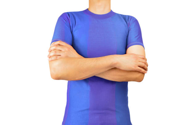cropped image of a young soccer player with crossed arms wearing blue tshirt isolated on white background.