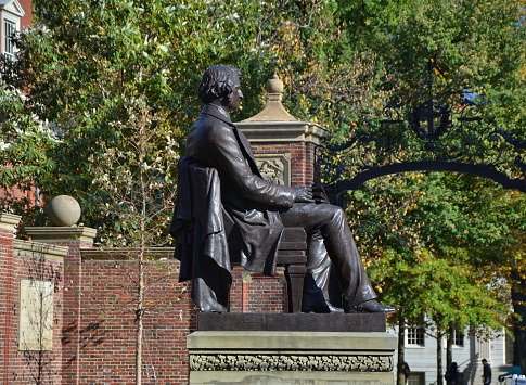 CAMBRIDGE, USA - OCTOBER 20, 2014: Statue of Charles Sumner in front of Harvard University entrance. Harvard is the most prestigious and oldest university in United States