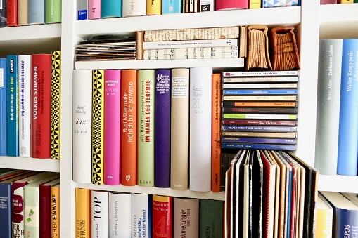 Filled book shelves with books, old vinyls, compact discs and cassettes