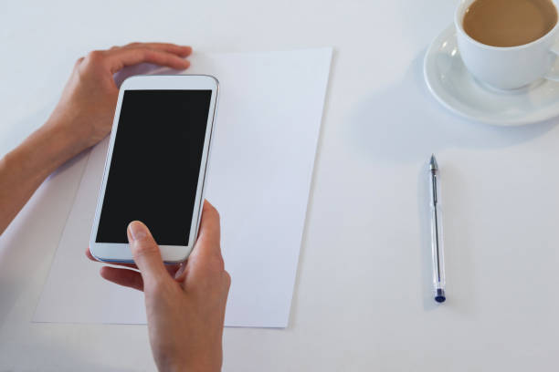 istock Businesswoman using smart phone at table 824223790