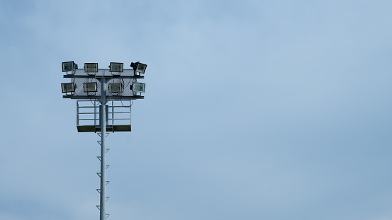 Spotlight of football stadium on blue sky blackground.