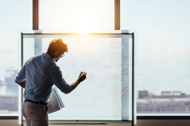 entrepreneur putting his business ideas on whiteboard in boardroom. - writing whiteboard men businessman imagens e fotografias de stock