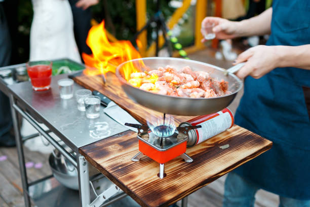 flambe. smażone krewetki królewskie na żelaznej patelni. główny kucharz wylewa alkohol i ogień. - pan frying pan fire fried zdjęcia i obrazy z banku zdjęć