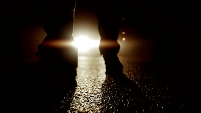 Silhouette of a Mysterious Person Standing in Front of Headlights.