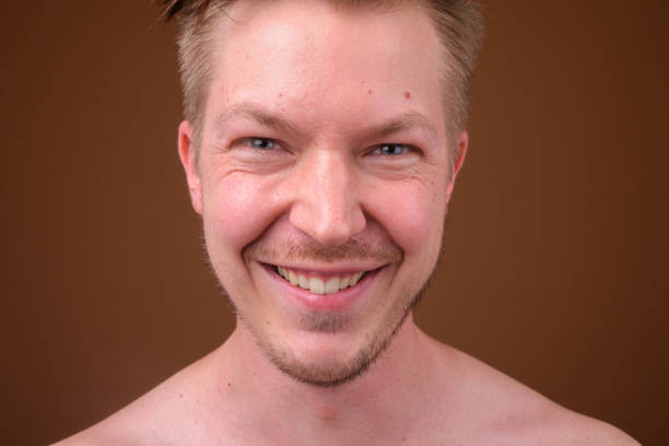 istock Studio shot of young handsome man shirtless while grooming against colored background 824238826