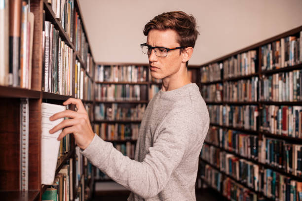 istock University student taking a book from shelf in library 824239312