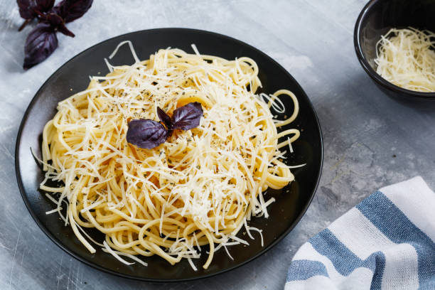 istock Black plate with Italian spaghetti with basil and parmesan on a gray table 824242440
