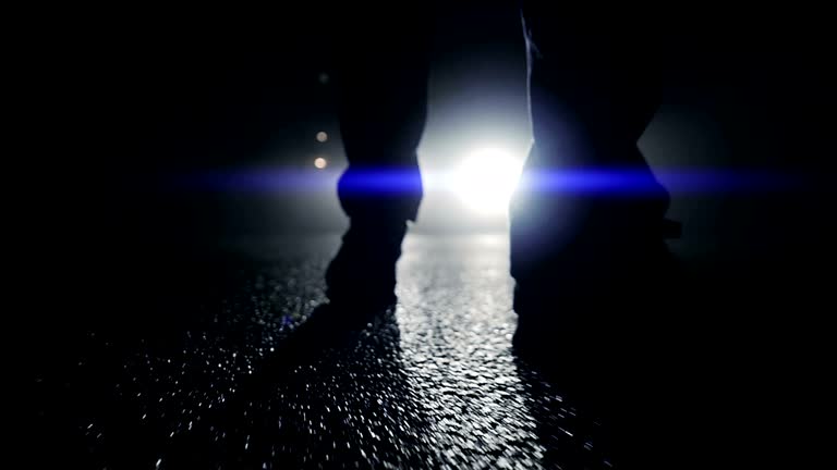 Outlines of Man Standing in Front of a Car in the Dark. At Night with Shadows and Back Light.