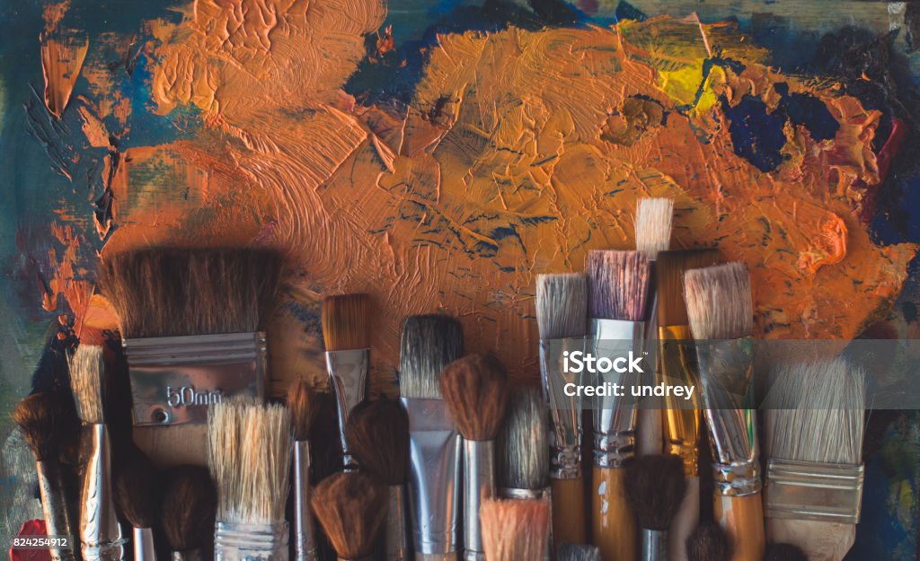 Fotografía vista superior del pincel madera set diferentes con paleta vieja en el fondo. - Foto de stock de Arte libre de derechos