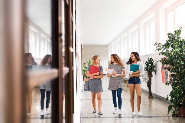 istock Teenage students walking in high school hall during break. 824255188