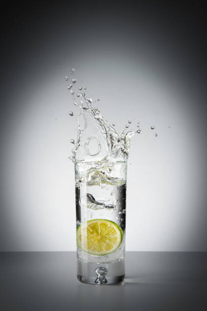 istock Lime splash into glass of water 824260314
