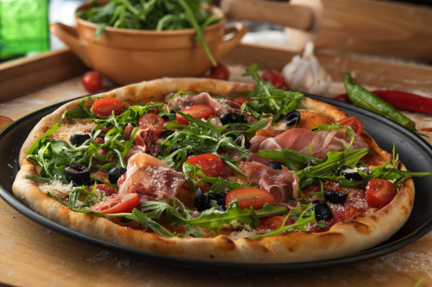 istock Traditional pizza with prosciutto and arugula 824260512