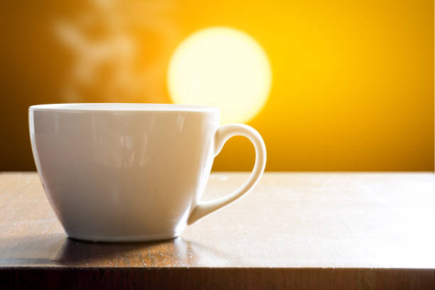 istock Cup of coffee on wooden table in sunrise 824260616