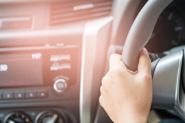 istock hand holding a car's steering wheel 824263434