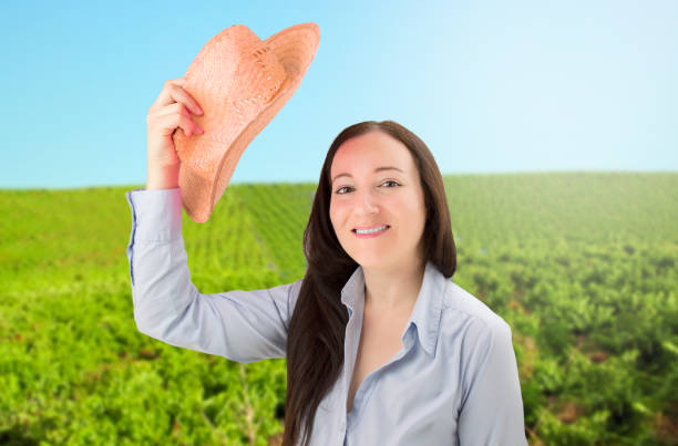 Business woman waving her sun hat in a vineyard at Spain