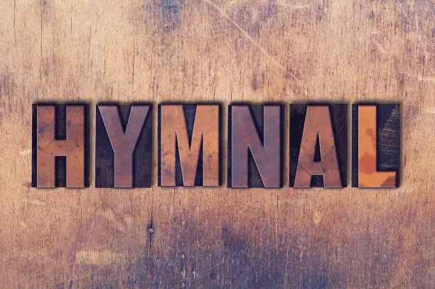 The word Hymnal concept and theme written in vintage wooden letterpress type on a grunge background.