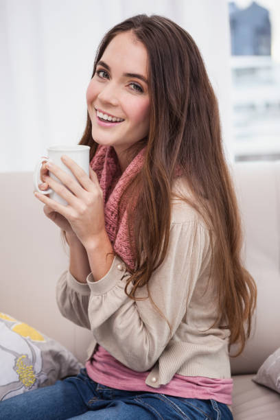 istock Pretty brunette having coffee on the couch 824274316