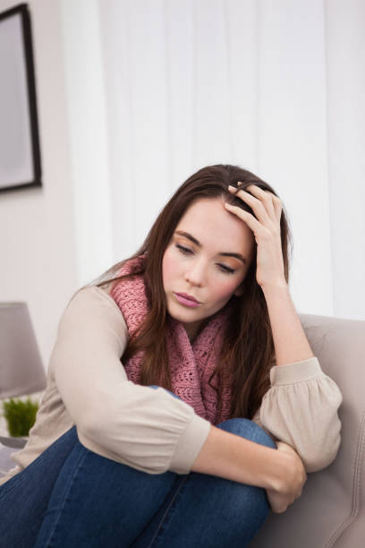 istock Pretty brunette feeling sad on the couch 824274330