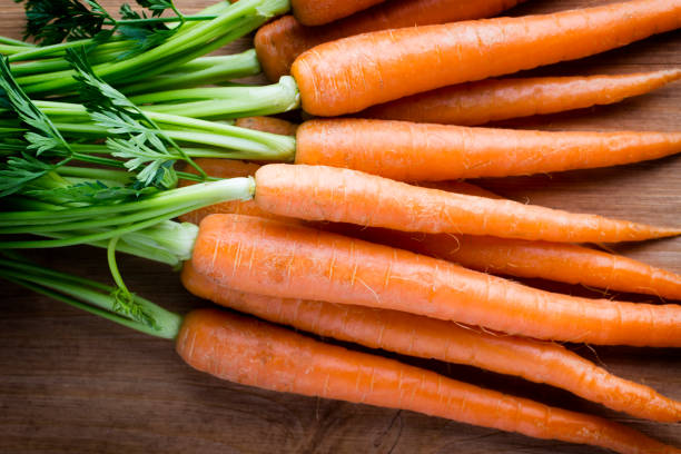 istock Fresh carrots on the wooden background. 824277252