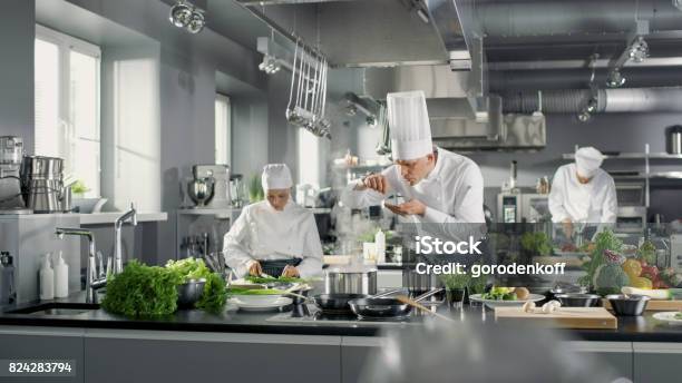 Berühmten Koch Arbeitet In Einer Großen Küche Mit Seiner Hilfe Küche Ist Voller Essen Gemüse Und Kochen Gerichte Er Versucht Geschmack Stockfoto und mehr Bilder von Kochberuf