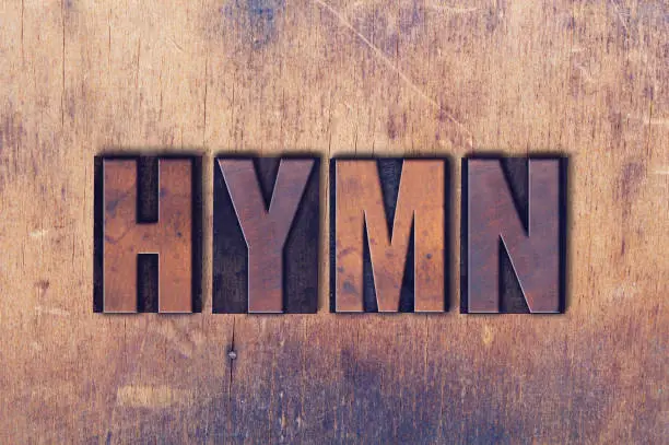 The word Hymn concept and theme written in vintage wooden letterpress type on a grunge background.