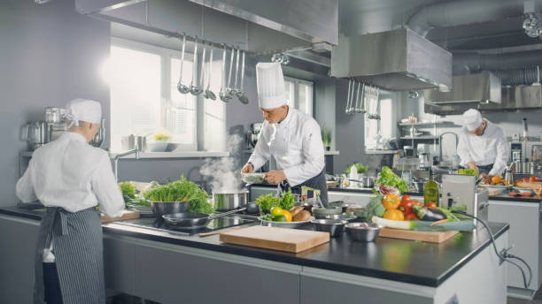 istock Big and Glamorous Restaurant Busy Kitchen, Chefs and Cooks Working on their Dishes. 824283912