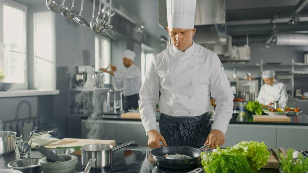 istock Famous Restaurant Chef Fries Fish on a Hot Pan. He Works in a Modern Kitchen. 824283926