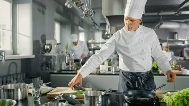 istock Famous Restaurant Chef Takes and Puts Fish on a Hot Pan. He Works in a Modern Kitchen. 824283938