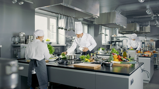 Grande y glamoroso restaurante ocupado cocina, Chefs y cocineros trabajando en sus platos. photo