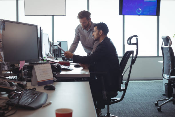 istock Male business colleagues discussing over documets at desk 824309780
