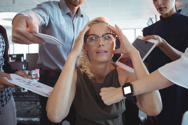 istock Frustrated businesswoman amidst team holding technologies 824313084