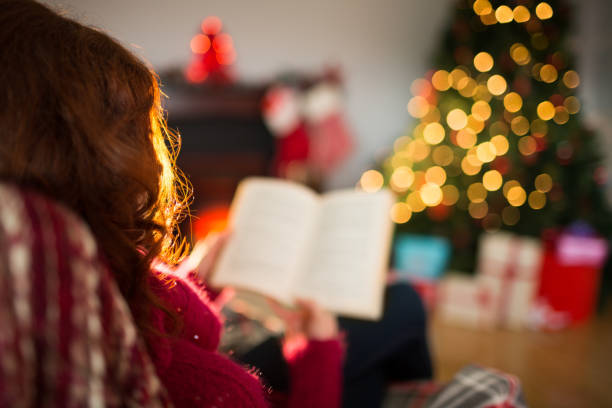 istock Rear view of redhead reading at christmas 824317338