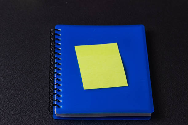 azul libreta en espiral con una pegatina - spiral notebook ring binder old paper fotografías e imágenes de stock