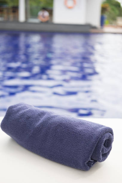 istock Blue towel roll on sunbeds at swimming pool 824319632