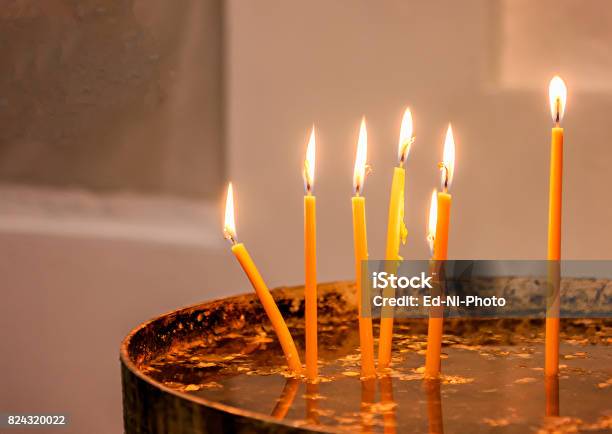 Close Up Of Thin Yellow Candles Burning Stock Photo - Download Image Now - Burning, Candle, Candlelight